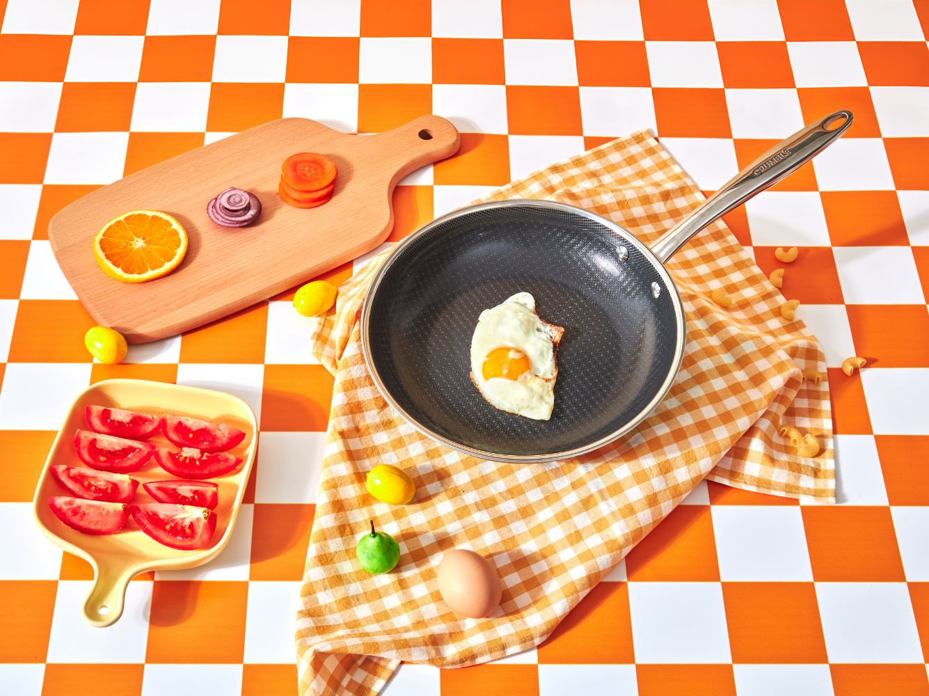Crumble Hybrid frypan with a fried egg on an orange checkerboard surface